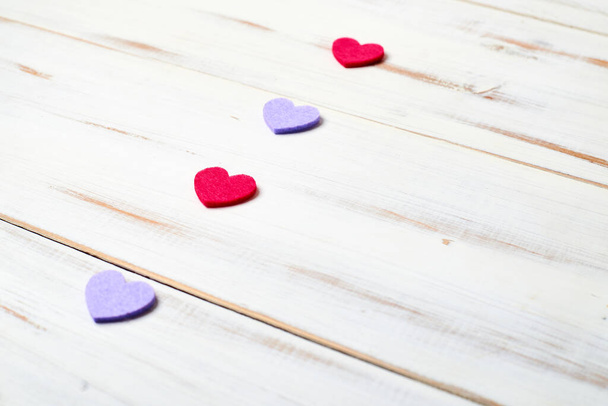 A row of multi-colored hearts on a white wooden background. - Fotografie, Obrázek