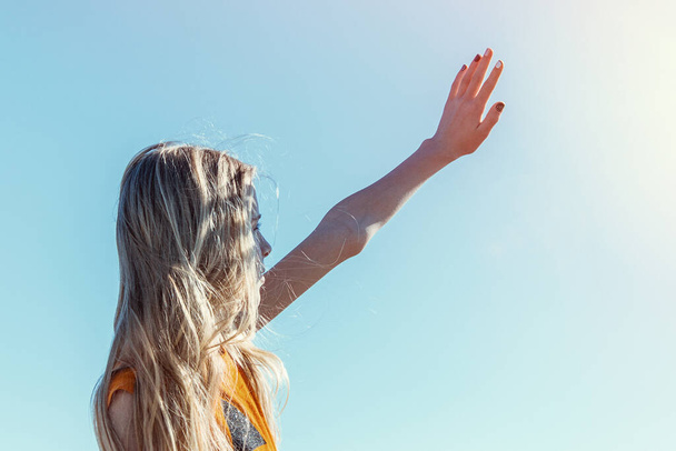 Teen girl stretches her arms to the sun. The concept of adolescent transition. - Photo, Image
