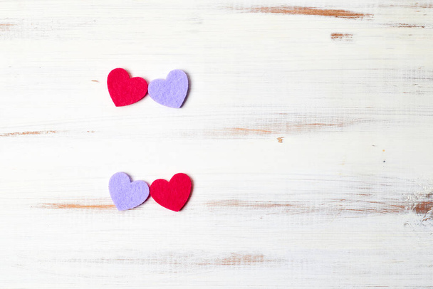 Two pairs of hearts on a white wooden background. - 写真・画像