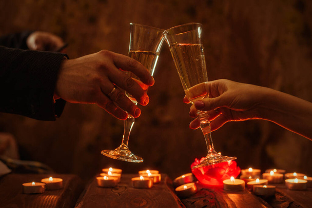 Man and woman with glasses of wine. Romantic dinner by candlelight. - 写真・画像