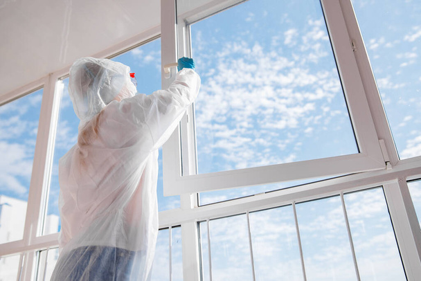Woman in biohazard medical mask on self isolation quarantine breathes fresh air on balcony with open window - Φωτογραφία, εικόνα