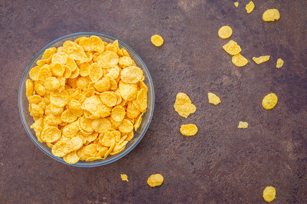 Pile in a bowl of milk of corn flakes dark background - Photo, Image