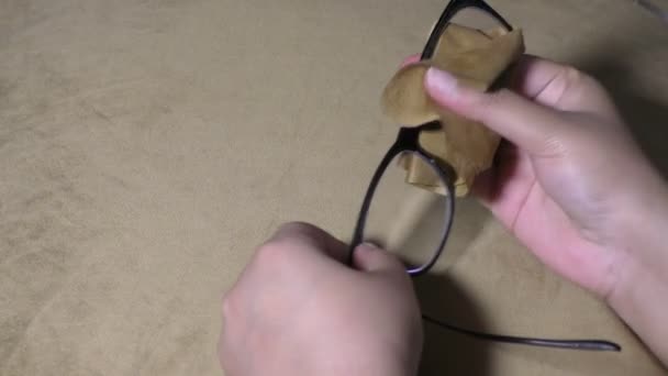 Egy lány kézzel és ruhával tisztítja a szemüveg viseletét.. - Felvétel, videó