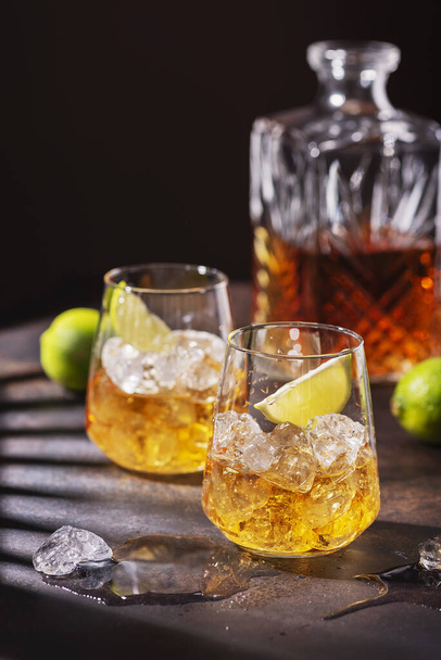 Cuban strong rum with ice and lime, summer concept with a strong shadows, selective focus image - Photo, image