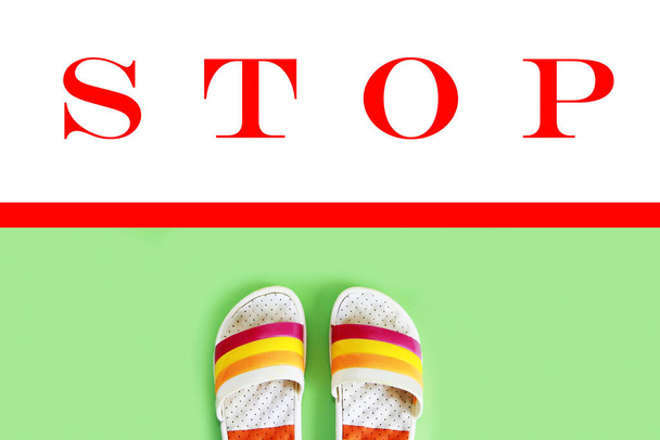 zapatillas de playa pizarras delante del rojo una línea y señal de stop
 - Foto, Imagen