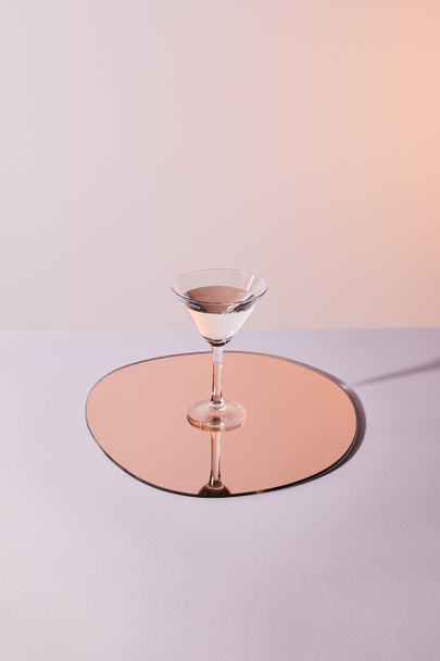 cocktail glass with liquid on mirror with reflection - 写真・画像