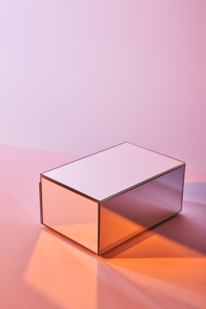 kubus met lichtreflectie op het oppervlak op een paarse en roze achtergrond - Foto, afbeelding