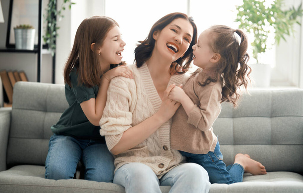 Happy mother's day! Mom and her daughters children girls are playing, smiling and hugging. Family holiday and togetherness.                                  - Φωτογραφία, εικόνα