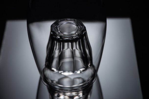 close up view of shot glass in wine glass in dark - Foto, Imagen