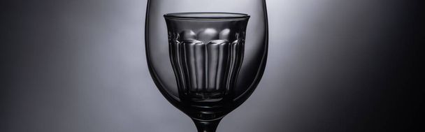 close up view of shot glass in wine glass in dark, panoramic shot - Фото, изображение