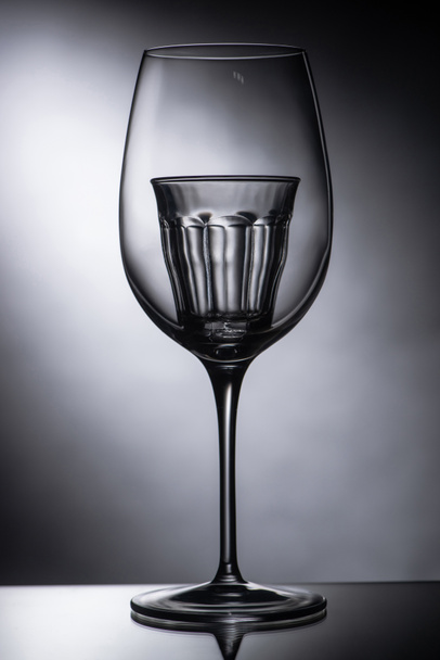vaso de chupito vacío en copa de vino sobre fondo oscuro
 - Foto, Imagen