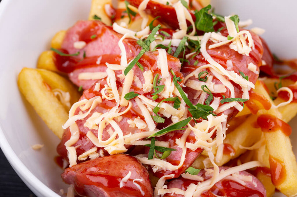 Salad with sausage, grated cheese, potatoes and ketchup with greens - Fotó, kép