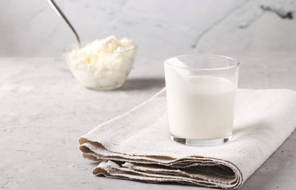 Kefir or Ayran fermented drink in glass and cottage cheese in a bowl on a light gray background, Space for text, Close up - Φωτογραφία, εικόνα