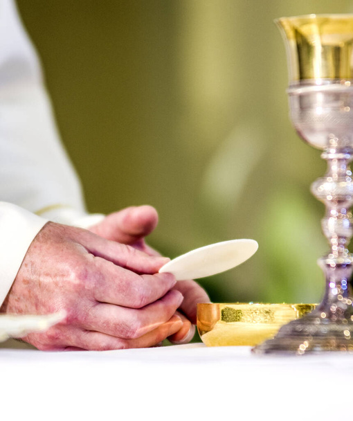 durante a celebração da Missa as mãos do sacerdote, como as mãos do Papa Francisco, consagrar a hóstia que se torna o corpo de Cristo
 - Foto, Imagem