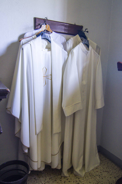 kleding en gewaden van de priester voor de mis in de oude sacristie van de kerk - Foto, afbeelding
