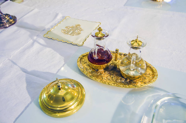 altar de la iglesia con un pequeño frasco de vino listo para convertirse en la sangre de Jesucristo durante la misa
 - Foto, imagen
