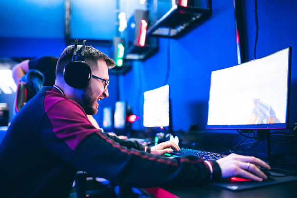 Professionelle Spieler spielen Turniere Online-Videospiele Computer mit Kopfhörern, rot und blau - Foto, Bild
