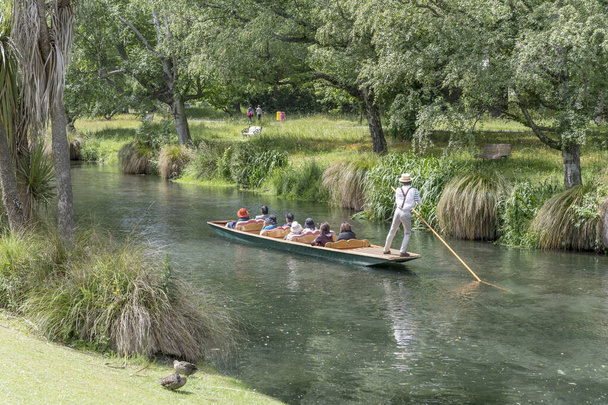 CHRISTCHURCH, NUEVA ZELANDA - 03 de diciembre de 2019: Paisaje urbano con barco turístico en el río Avon en Botanic Gardens, filmado a plena luz de primavera el 03 de diciembre de 2019 en Christchurch, South Island, Nueva Zelanda
 - Foto, Imagen