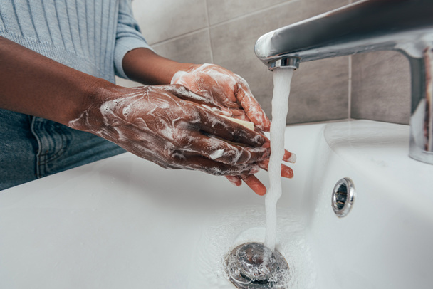 bijgesneden uitzicht van Afrikaans amerikaanse vrouw wassen handen met zeep - Foto, afbeelding