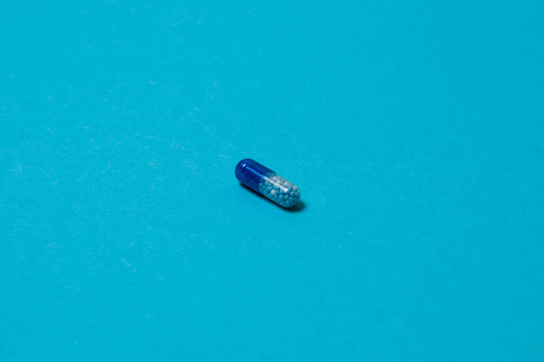 Pill on blue background, isolate, with place for text. - Zdjęcie, obraz