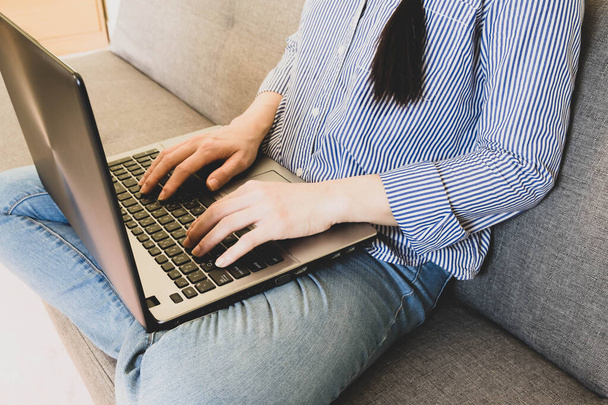 electieve focus vrouw hand droeg blauw gestreept shirt Typing op keybord, werk online lifestyle ontspannen thuis met koffie, thuis werken met laptop, werk van thuis uit - Foto, afbeelding