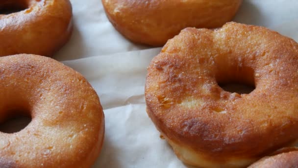 Recién frito grandes rosquillas redondas en la mesa en la cocina del hogar. Donuts sin esmalte y en polvo
 - Imágenes, Vídeo