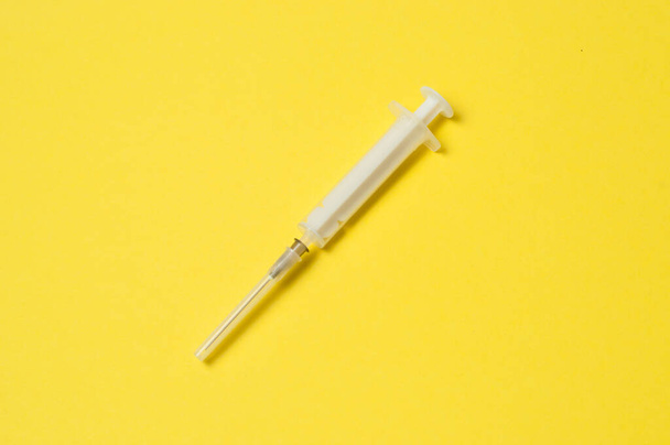 Medical syringe isolated on yellow background - Photo, Image