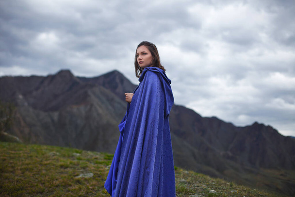 Девушка в великолепном голубом платье гуляет по горам
. - Фото, изображение