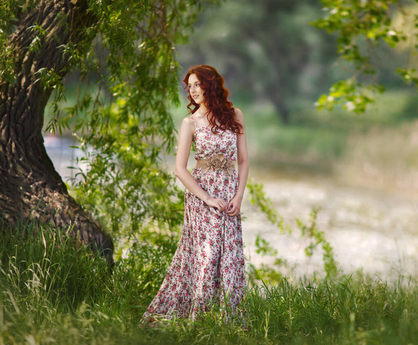 Rudowłosa dziewczyna spaceruje po lesie. Letnia sesja zdjęciowa - Zdjęcie, obraz