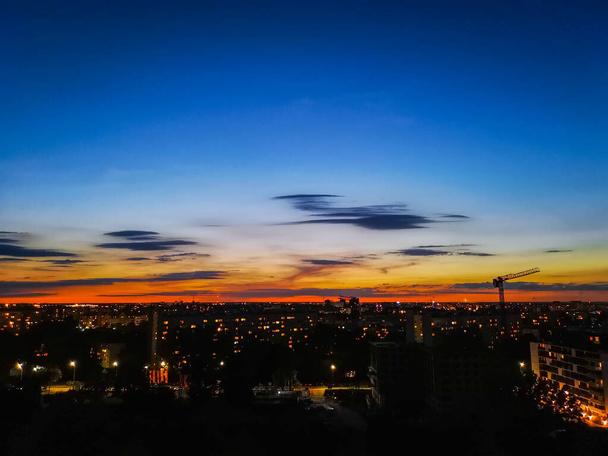 Cielo nuvoloso blu e arancione subito dopo il tramonto e luci della città
 - Foto, immagini