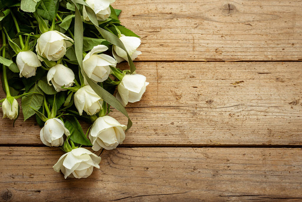 White roses on a background of old wooden boards. Vintage. Frame. Congratulation - Photo, Image
