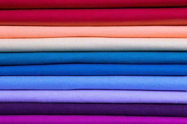 Background from colored cotton clothes. Colors of rainbow. Colored horizontal strips of fabric. - Foto, Bild