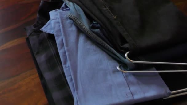 Roupas como camisas e jeans na mesa prontas para serem embaladas
 - Filmagem, Vídeo