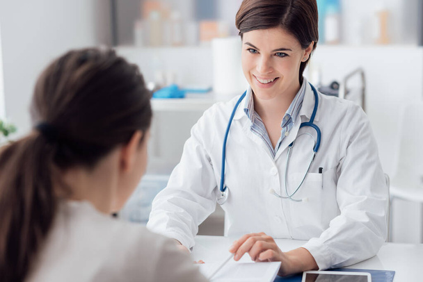 Женщина-врач консультирует пациента и разъясняет медицинскую информацию и диагноз - Фото, изображение