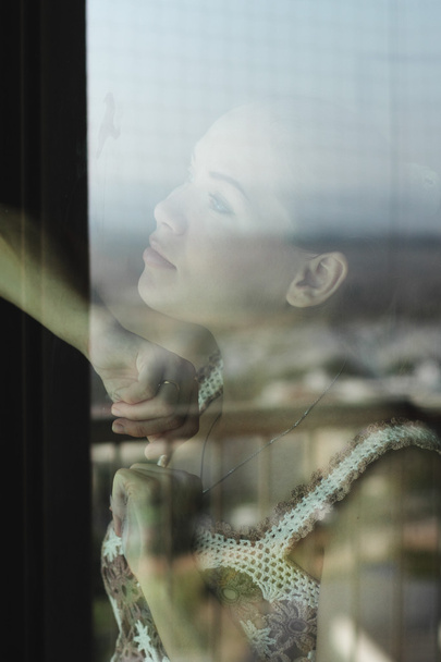 Woman looking through a window - Фото, зображення