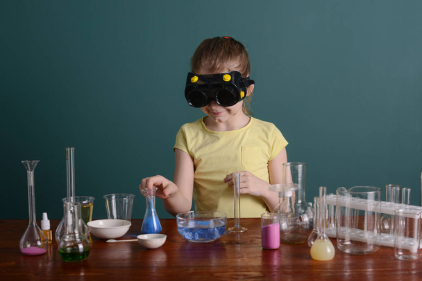 girl in safety glasses at home doing experiments with chemicals. school experiments at home. - Zdjęcie, obraz