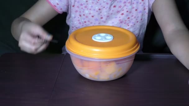 Девушка открывает пластиковую коробку с фруктами, чтобы поесть
 - Кадры, видео