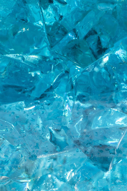 Текстура и фон голубых кристаллов льда в каплях пресной воды. Ледяной свежий фон. Классический синий фон. Макрофото декоративного синего стекла
. - Фото, изображение