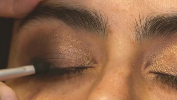 Makeup καλλιτέχνης με γρήγορες κινήσεις με πινέλο εφαρμόζει σκιά - Πλάνα, βίντεο