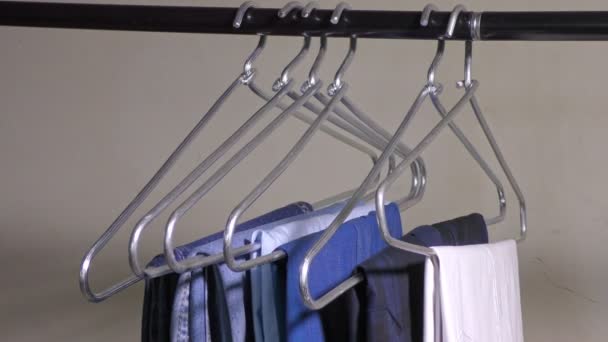 Koszulki i dżinsy w wieszaku na wędce do przechowywania - Materiał filmowy, wideo