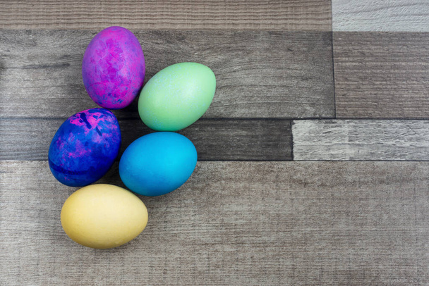 Alcune uova di Pasqua luminose sullo sfondo di legno
 - Foto, immagini
