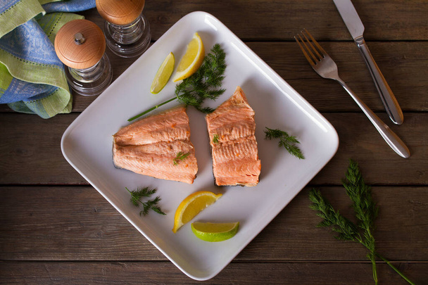 Poached salmon fillets. Boiled salmon on white plate. Healthy diet fish dish. View from above, top studio shot - Foto, imagen