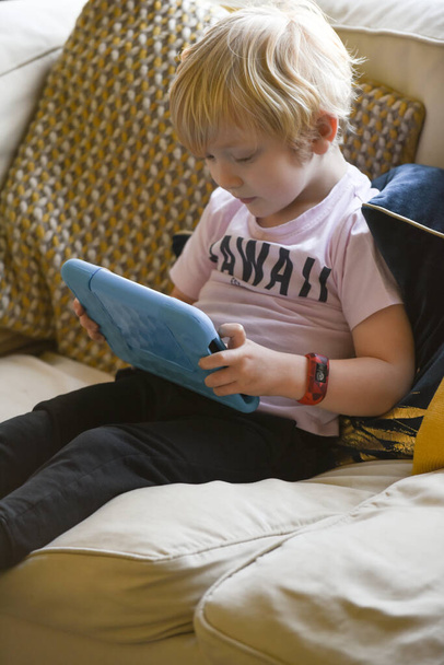Niño usando un dispositivo de tableta con aplicación de aprendizaje en casa
 - Foto, imagen