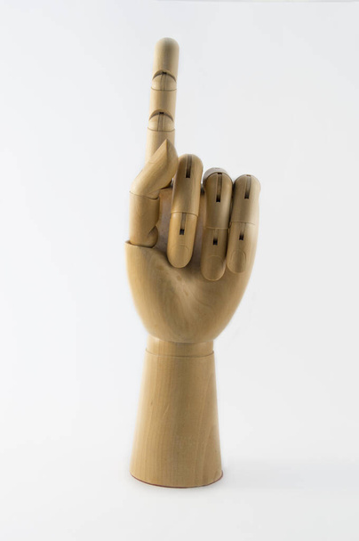 articulated wooden hand with index finger raised pointing up - Fotografie, Obrázek