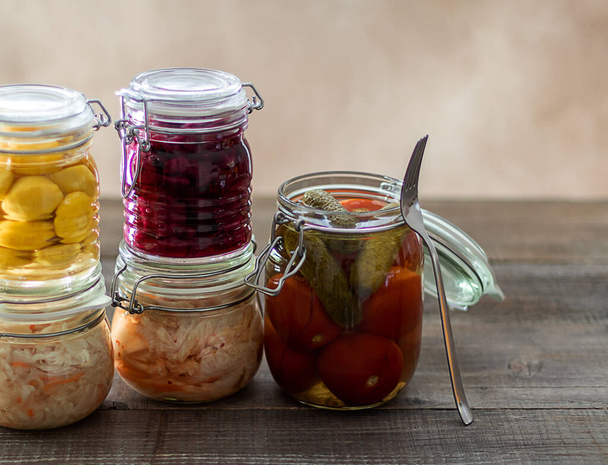 Fermented cabbage, pickled tomatoes, pickled cucumbers, pickled pattypans in glass jars. - Photo, Image
