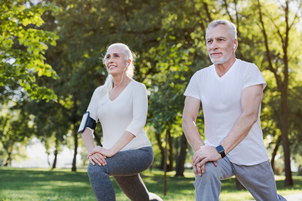 Portrait of active senior couple doing warm up exercises while s - Foto, Imagem
