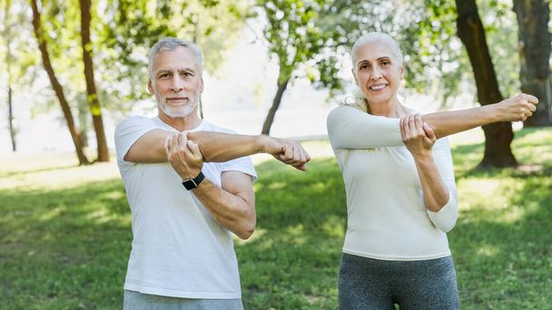 Senior couple stretching in park outdoors before yoga and fitnes - Foto, Imagen