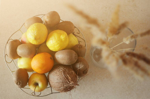 Vue du dessus du bol de nombreux fruits sur la table avec des plantes de paille rustique dans un vase
 - Photo, image
