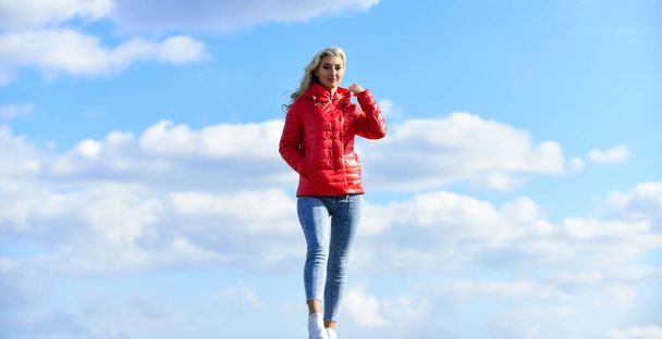 Fashion outfit. Windy day. Girl red jacket cloudy sky. Wind of changes. Female psychology. Woman fashion model outdoors. Woman enjoy cool weather. Matching style and class with luxury and comfort - Photo, image