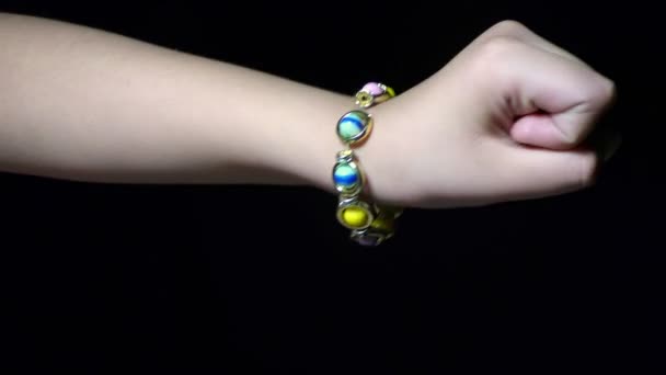 Una donna che indossa gioielli e mostra braccialetto di perline polso in mano
. - Filmati, video